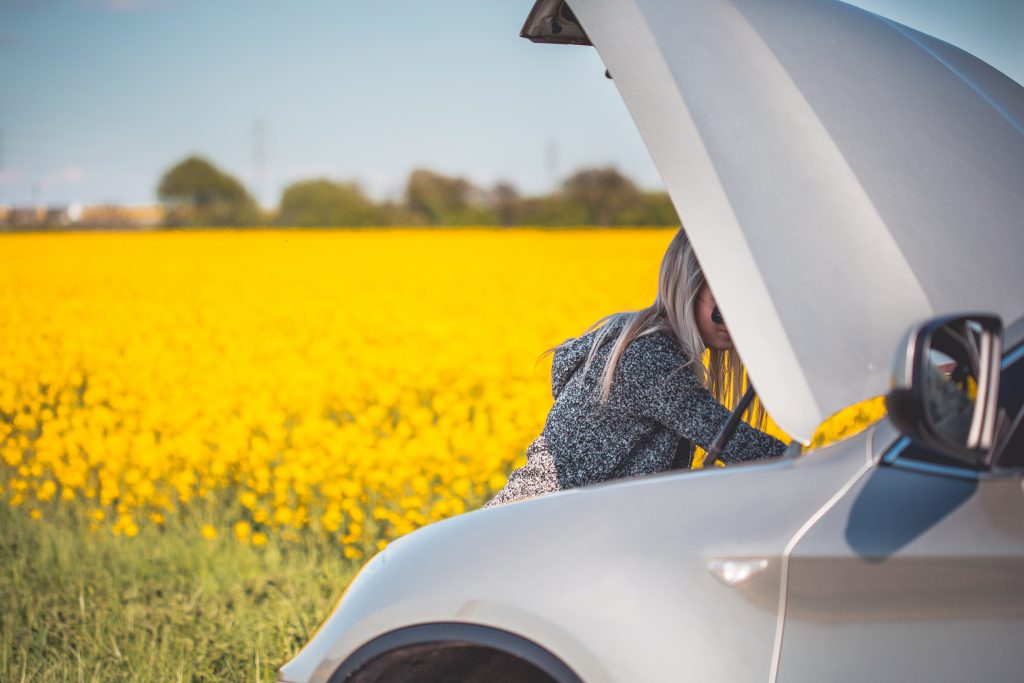 young-woman-trying-to-check-and-repair-her-broken-car-picjumbo-com